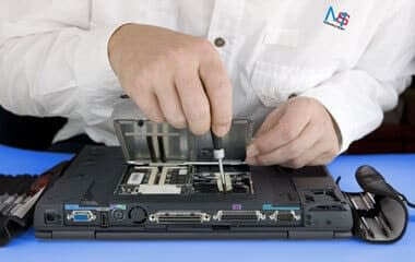 Pracownik firmy MS Komputery naprawia laptopa